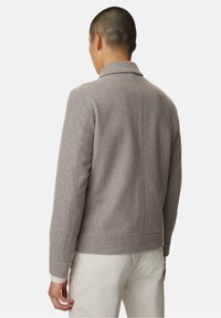 Grå uld-blend jakke med krave, struktureret overflade og skræddersyet pasform. Har ribbede manchetter og et rent, minimalistisk design bagpå.
