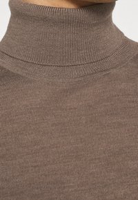 Brauner, gerippter Rollkragenpullover aus weichem, strukturiertem Strickstoff. Verfügt über einen enganliegenden Kragen und ein nahtloses Design für optimalen Komfort.