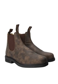 Brązowe skórzane botki za kostkę z elastycznymi panelami bocznymi, teksturowaną powierzchnią i pętlami z tyłu. Solidne czarne gumowe podeszwy.