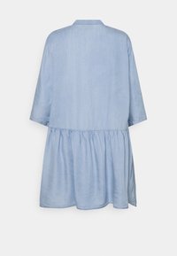 Abito in denim azzurro chiaro con vestibilità ampia, maniche a tre quarti, vita bassa e gonna arricciata, visto da dietro su sfondo bianco.