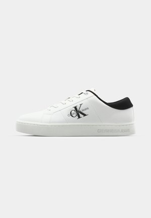 White sneaker with black accents, smooth synthetic material, lace-up design, featuring Calvin Klein Jeans logo on the side and textured sole.