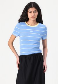 T-shirt azzurro chiaro a righe con maniche corte, presenta un collo rotondo e un piccolo logo "GAP" sulla parte anteriore.