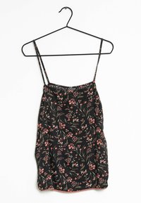 Blomstrig linne med tunna axelremmar, svart bakgrund, röd och grön blommönster, mjuk tyg, böjd fåll och rynkdetaljer vid bysten.