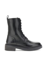 Bota de tobillo negra de cuero con cordones, con suela gruesa y una lengüeta en la parte posterior, mostrada de lado sobre un fondo blanco.