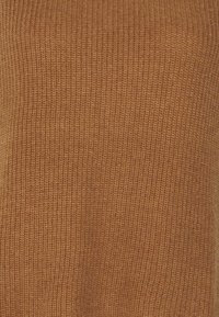 Geribbelde gebreide stof in een warme bruine kleur met een zachte textuur. Het ontwerp heeft constante verticale lijnen en een gladde afwerking.