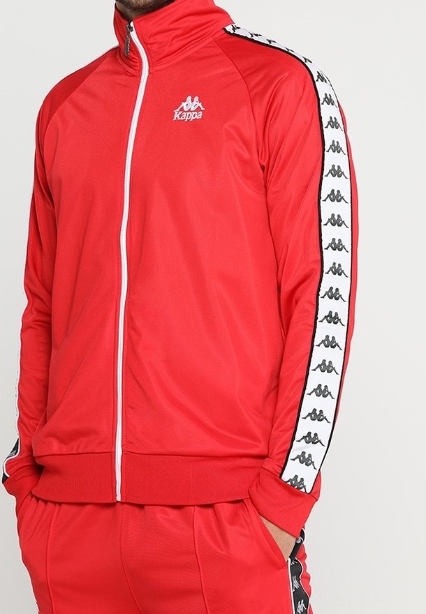 Rote sportliche Zip-Jacke aus glattem Material, ausgestattet mit einem weißen Kappa-Logo auf der Brust und kontrastierenden seitlichen Streifen mit schwarzen Logos.