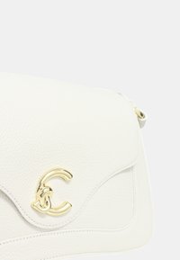 Borsa a tracolla bianca in pelle con una superficie texturizzata, caratterizzata da un'accento in hardware dorato con un logo a doppia C e una chiusura a pattina.