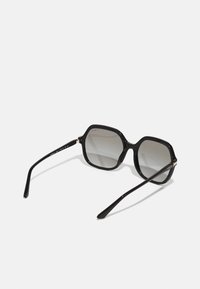 Ochelari de soare negri, de formă rectangulară, cu lentile gradient. Au rame groase, finisaj lucios și accente subtile de aur pe brațe.