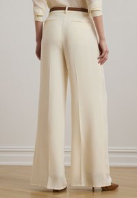 Κρεμ παντελόνι φαρδιάς γραμμής από ελαφρύ ύφασμα, με θηλιά ζώνης στο πίσω μέρος, δύο πίσω τσέπες και ομαλή υφή.
