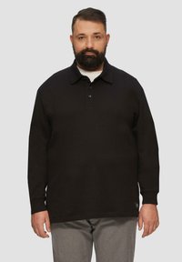 Zwarte lange mouw polo met een kraag en drie knopen, gecombineerd met lichtgrijze broek. Gladde textuur, medium pasvorm.