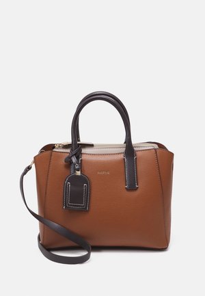 Bruine leren handtas met zwarte handvatten en label, beige rits en afneembare zwarte schouderriem op witte achtergrond.