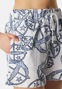 Lichtgewicht, gemusterde shorts met een blauw-wit ontwerp met cirkelvormige motieven en sterren, elastische taille en zijzakken.