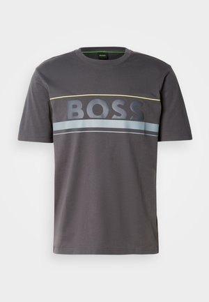 Siva bombažna majica s krožnim izrezom. Vsebuje velik logo "BOSS" v temno sivi barvi, poudarjen z rumenimi in modrimi vodoravnimi črtami.