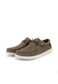 Scarpe slip-on in suede marrone con suola in gomma bianca, dotate di punta arrotondata, lacci in pelle decorativi e dettagli in legno.
