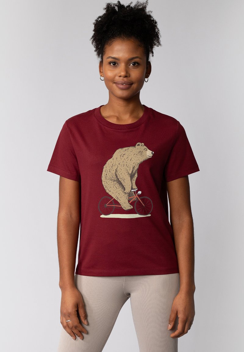 Bordeaux katoenen t-shirt met een afbeelding van een beer die op een rode fiets rijdt. Het ontwerp bevat een gedetailleerde illustratie en een ronde hals.