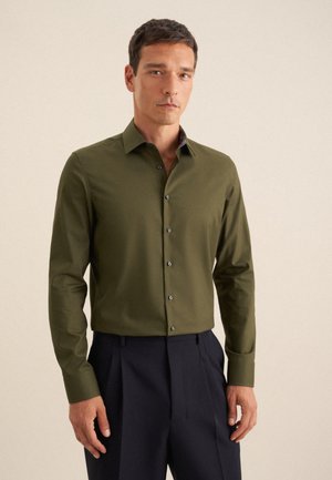 Camicetta verde oliva a maniche lunghe con colletto aderente e patta con bottoni frontali. Presenta dettagli colorati a motivo all'interno del colletto.
