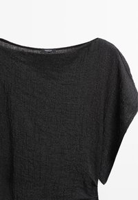 Sort tekstureret kortærmet bluse med bred halsudskæring og synligt Massimo Dutti-mærke på hvid baggrund.