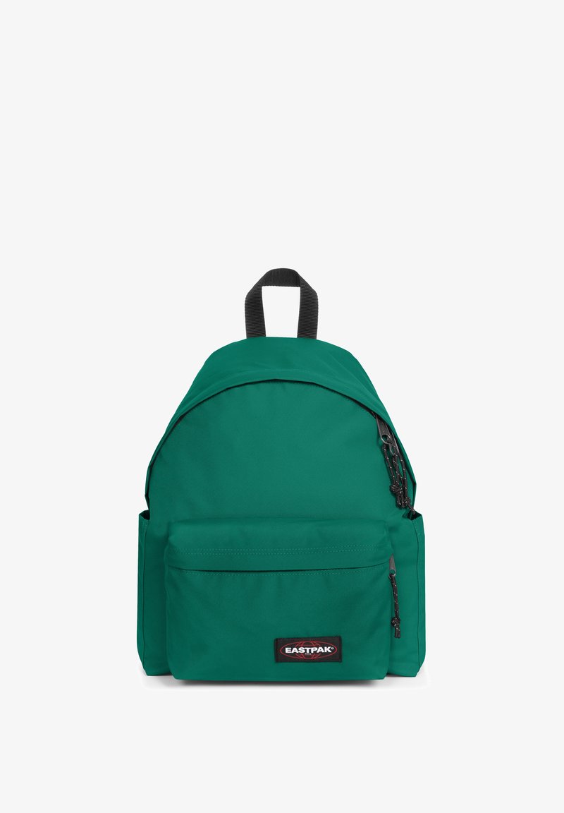 Sac à dos vert en tissu lisse, avec un dessus arrondi, une poche zippée à l'avant et un patch logo noir. Équipé de bretelles réglables et d'une poignée supérieure.