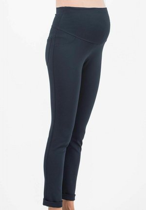 Schwangerschaftsleggings in Dunkelblau, aus elastischem Stoff gefertigt, mit einem breiten, glatten Bund und praktischen Seitentaschen. Eng anliegendes Design mit umgeschlagenen Säumen.