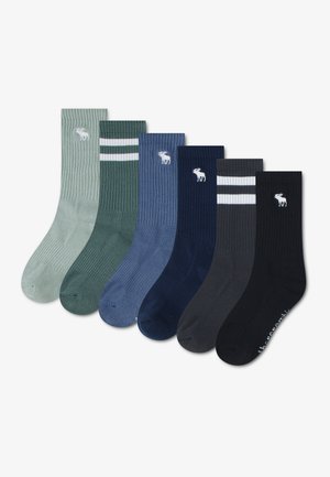 Six paires de chaussettes côtelées montantes en vert, vert foncé avec des rayures blanches, bleu, marine, gris foncé avec des rayures blanches et noir, chacune avec un logo élan blanc.
