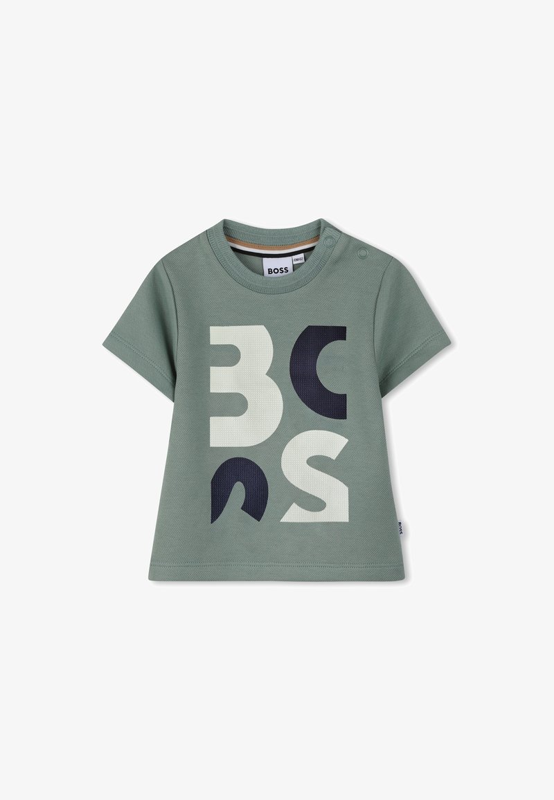 T-shirt en coton vert avec manches courtes, encolure ronde, logo imprimé en blanc et bleu marine, et deux boutons-pression sur l'épaule.