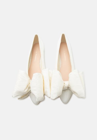 Ballerines blanches à bout pointu pour femmes avec de grands nœuds en tissu doux sur le devant, photographiées vue de dessus sur fond blanc.