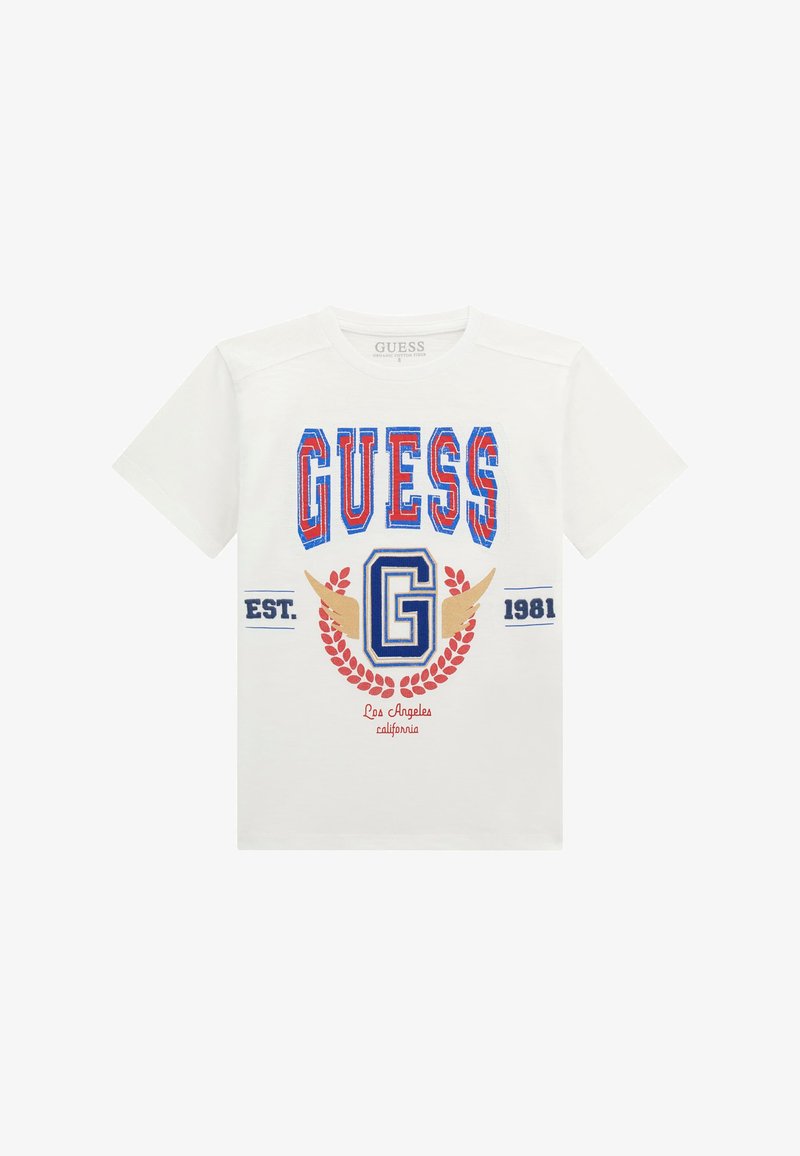 Bílý bavlněný tričko s barevným logem "GUESS" v červené a modré barvě, se zlatými akcenty a designem vavřínového věnce. Krátké rukávy.