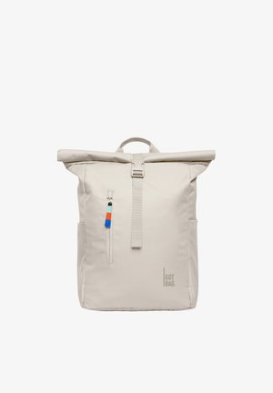 Beżowy plecak z rolowanym zamknięciem, z przednią kieszenią na suwak wyposażoną w niebieskie, pomarańczowe i czarne pętelki, górnym uchwytem oraz logo "GOT BAG" na dole po prawej stronie.