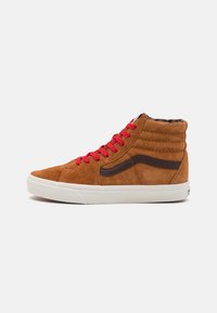 Zapatillas altas de ante marrón con cordones rojos, que cuentan con una franja lateral de cuero marrón y una suela de goma blanca. Estructura texturizada en el tobillo y la lengüeta.