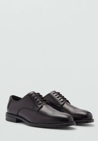 Black leather dress shoes with a smooth finish, lace-up design, rounded toe, and a flat sole. Visual features highlight simplicity and elegance.