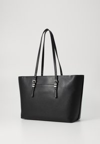 Black leather tote bag with a textured finish, two long handles, and silver hardware accents. Structured shape with a spacious interior.