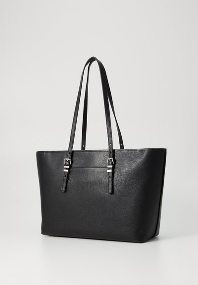 Sac fourre-tout en cuir noir avec une finition texturée, deux longues poignées et des accents en métal silver. Forme structurée avec un intérieur spacieux.