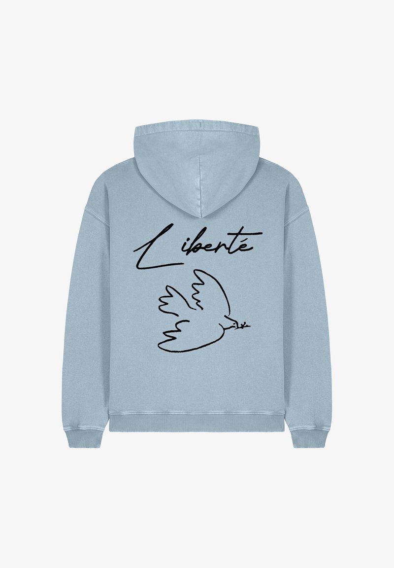 Sweat à capuche bleu clair avec un dessin en contour noir d'un oiseau tenant une branche d'olivier et le mot "Liberté" en cursive dans le dos.