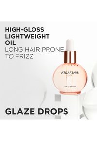 Kérastase Glaze Drops, botella redonda de vidrio con un ligero tinte rosa y gotero blanco, etiquetada como "Aceite ligero de alto brillo" para el control del encrespamiento.