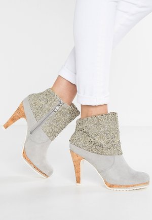 Gray suede ankle boots with floral-patterned fabric cuffs, cork heels, and a side zipper; smooth texture and structured design.