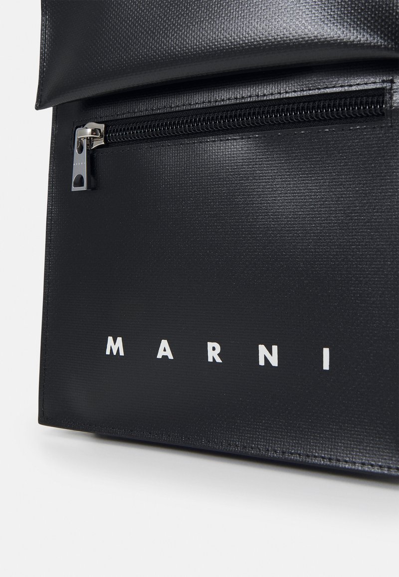 Borsa nera con texture, dotata di chiusura a zip, caratterizzata da un logo bianco "MARNI" ben visibile sul davanti e da un design liscio ed elegante.