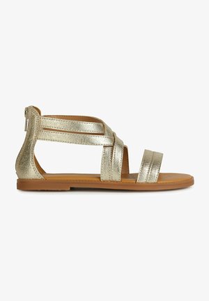 Gouden metallic sandalen met een open teenontwerp, voorzien van kruislings straps en een platte zool, aangevuld met een gestructureerde bovenkant en een rits aan de achterkant.