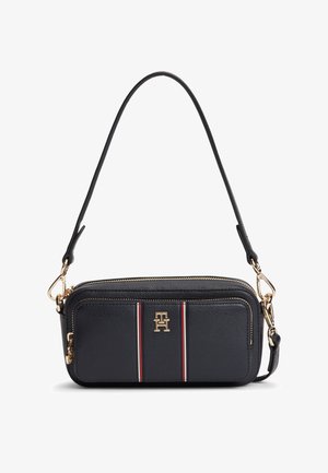 Μαύρο δερμάτινο τσαντάκι ώμου με χρυστό φερμουάρ και εξαρτήματα, με κόκκινες, λευκές και μαύρες ρίγες και χρυσό λογότυπο "TH" στην μπροστινή τσέπη.