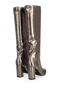 Botas metálicas bronce hasta la rodilla con un acabado suave, tacones cilíndricos altos y un detalle de cremallera lateral. Presenta costuras verticales sutiles.