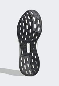 Semelle de chaussure en caoutchouc noir présentant un motif de semelle avec des sections en caoutchouc blanc et une découpe centrale pour une meilleure flexibilité.