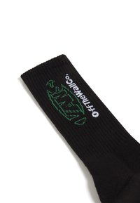 Schwarze Crew-Socke mit gerippter Textur, featuring ein grünes Grafik-Logo und weißen Text mit der Aufschrift "offthewall". Weiches, dehnbares Material.