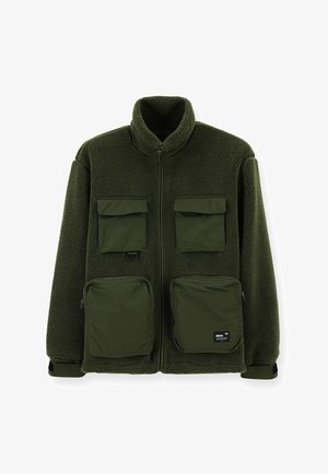 Green fleece jacket with a high collar, features four front pockets, zippered closure, and a soft, textured surface.