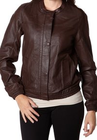 Hnědá kožená bomber bunda s kulatým výstřihem, elastickými manžetami a bočními kapsami. Hladká textura s jemnými šicími detaily.