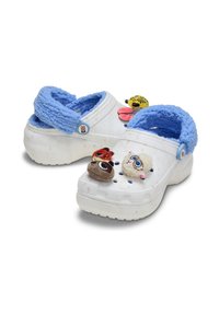 Zuecos blancos con correas de felpa azul claro, que presentan encantos decorativos con temática animal y agujeros de ventilación en la parte superior. Suela texturizada para mayor agarre.