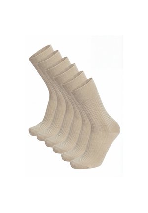 Fünf beige gerippte Knöchelsocken, versetzt in einer Reihe auf weißem Hintergrund.