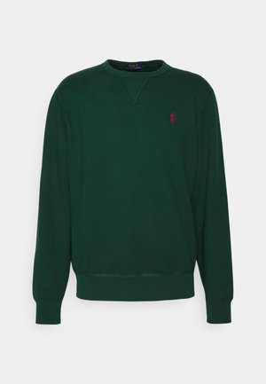 Tummanvihreä pyöreäkauluksinen collegepaita, jossa pitkät hihat ja pieni punainen brodeerattu Polo Ralph Lauren -logo rinnassa.