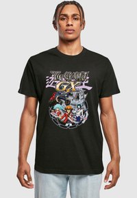 Black cotton t-shirt featuring a colorful graphic print of characters from Yu-Gi-Oh! GX in the center, with detailed designs and accents.