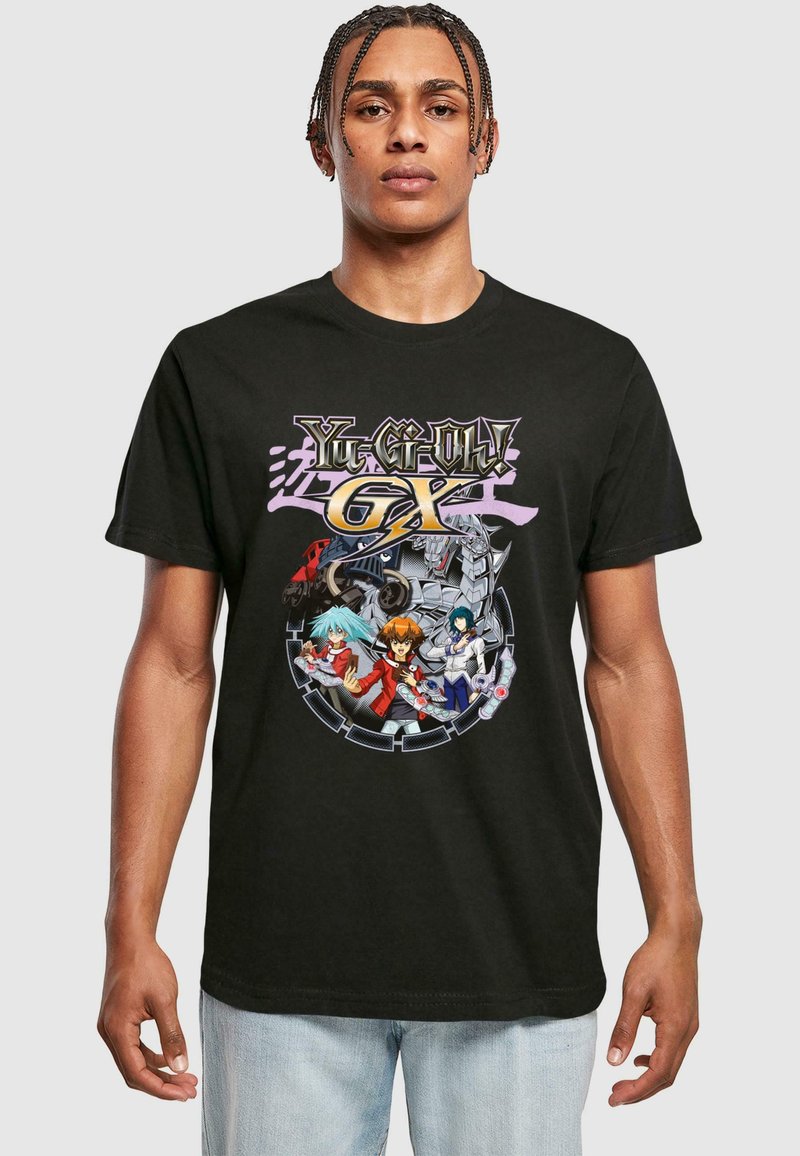 Black cotton t-shirt featuring a colorful graphic print of characters from Yu-Gi-Oh! GX in the center, with detailed designs and accents.