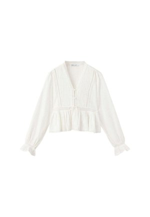 Blouse blanche à manches longues avec col en V, détails plis nervurés, boutonnage devant, taille à lien coulissant et volants aux poignets et à l’ourlet.