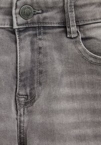 Jeans iz denima v bledi sivi barvi z gladko teksturo, z gumbom za zapiranje, sprednjim žepom in subtilnimi šivi.